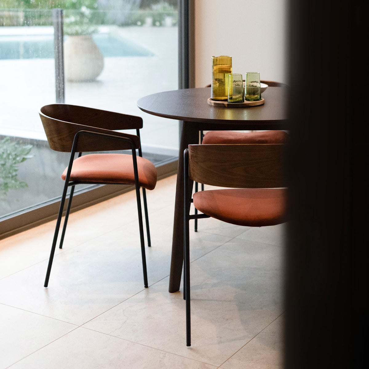 Deux chaises orange et bois foncé avec table ronde – Maison Pavane