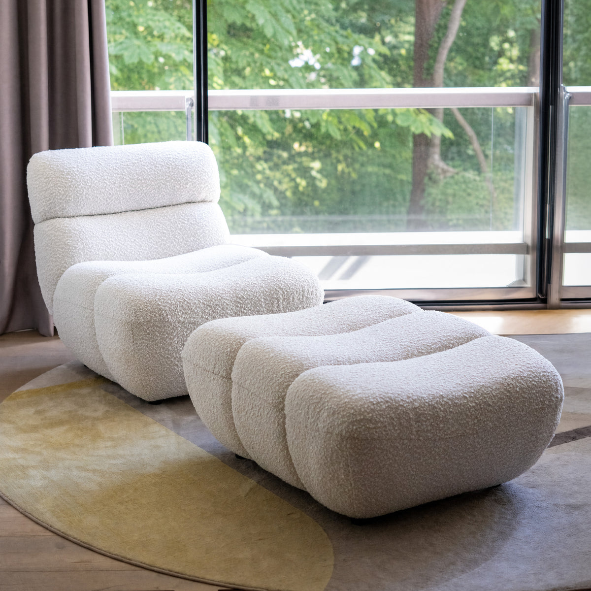 Fauteuil et repose-pied en tissu bouclé blanc confort grande fenêtre en arrière-plan – Maison Pavane