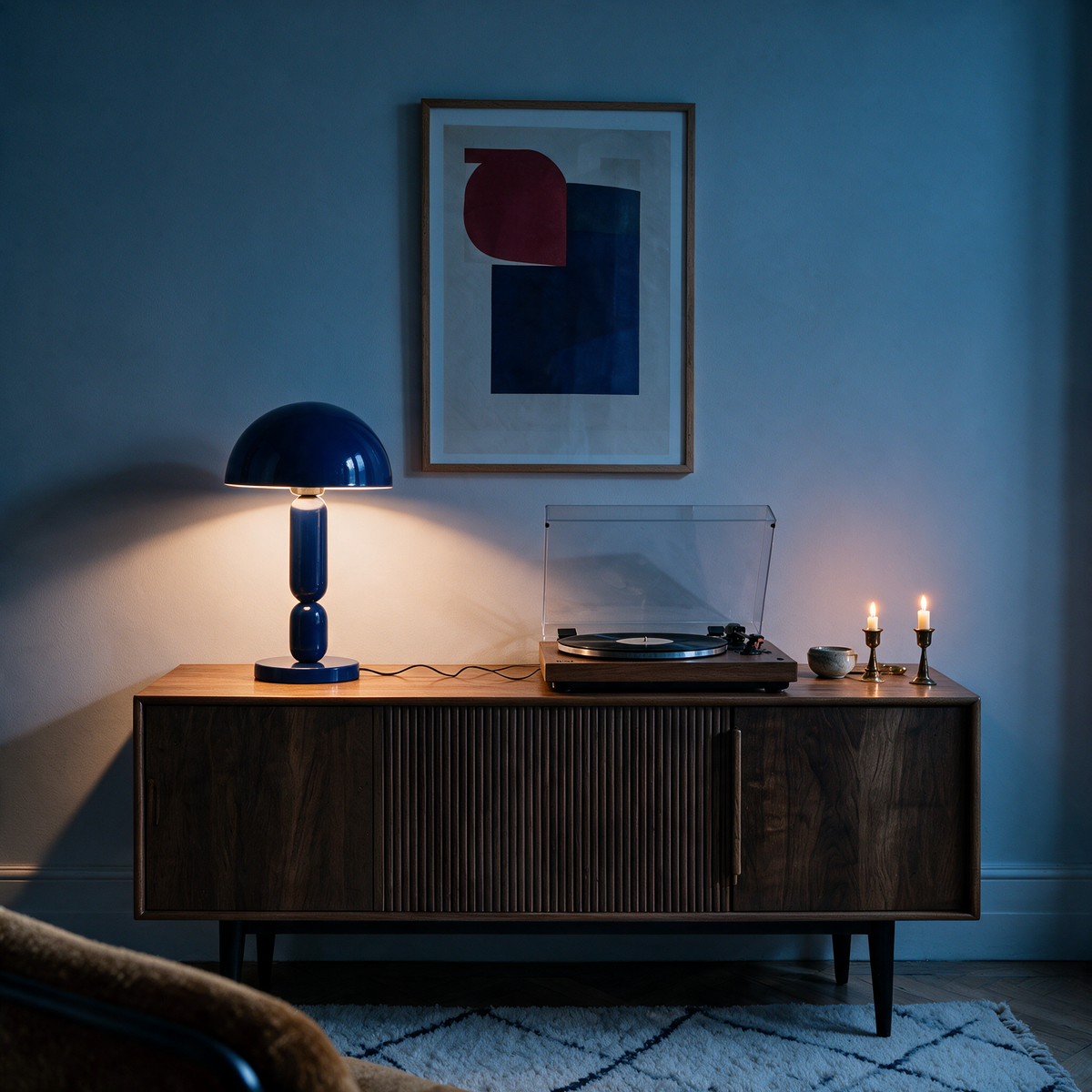 Petite lampe métal bleu roi allumée sur buffet en bois – Maison Pavane