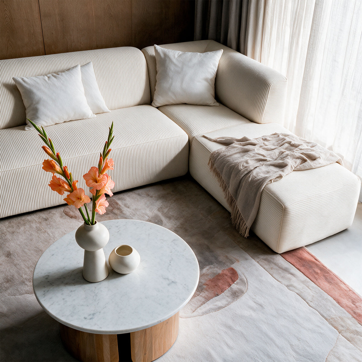 Vue du dessus salon canapé velours côtelé blanc confort et table basse ronde marbre et bois – Maison Pavane