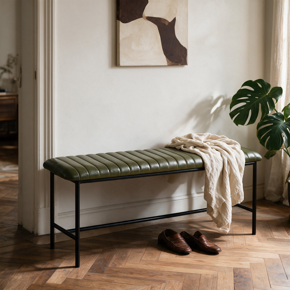 Vue trois-quarts banc cuir vert pieds métal noir – Maison Pavane